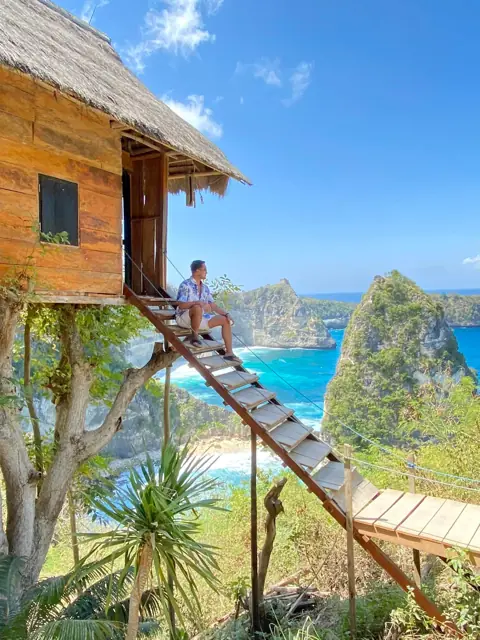 Merald on a cliffside treehouse above the sea in Bali
