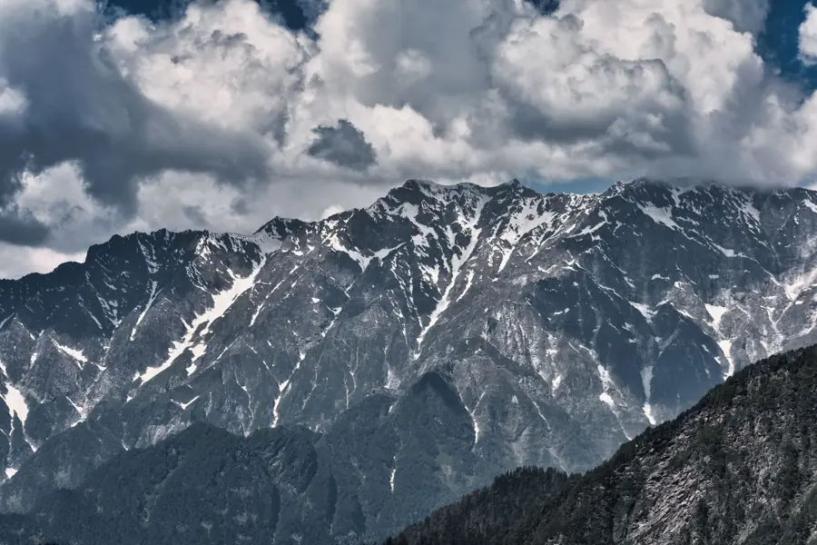 Snow-capped Himalayan peaks under a dramatic cloudy sky.