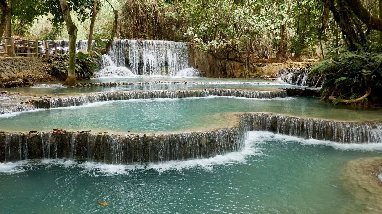 Turquoise pools spilling over tiered limestone falls at Kuang Si, near Luang Prabang, Laos